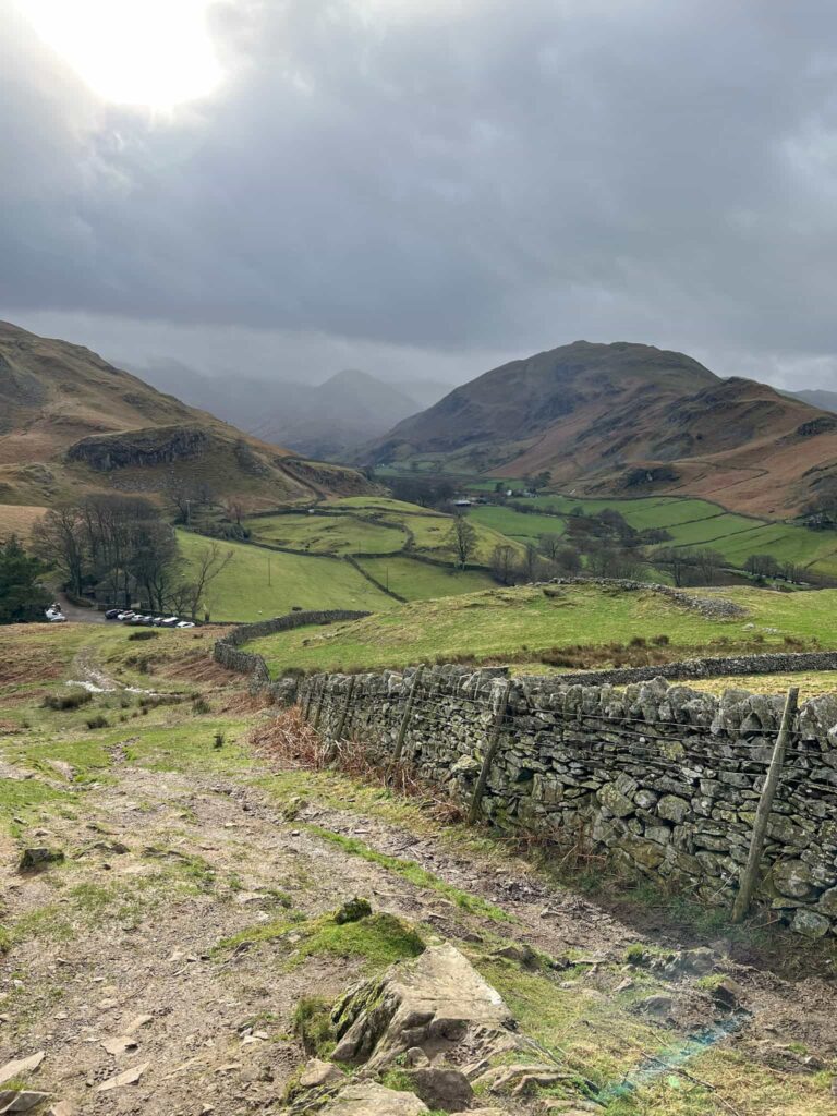 A dry stone wall leading off into the distance with some Lake District fells looming large
