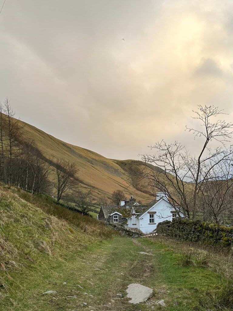 A white cottage at the foot of a Lake District fell
