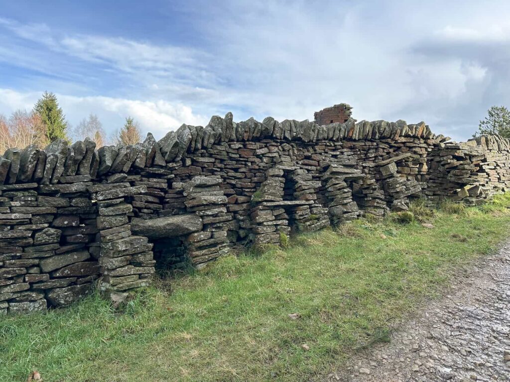 A dry stone wall with the word HADES spelled out in stone 