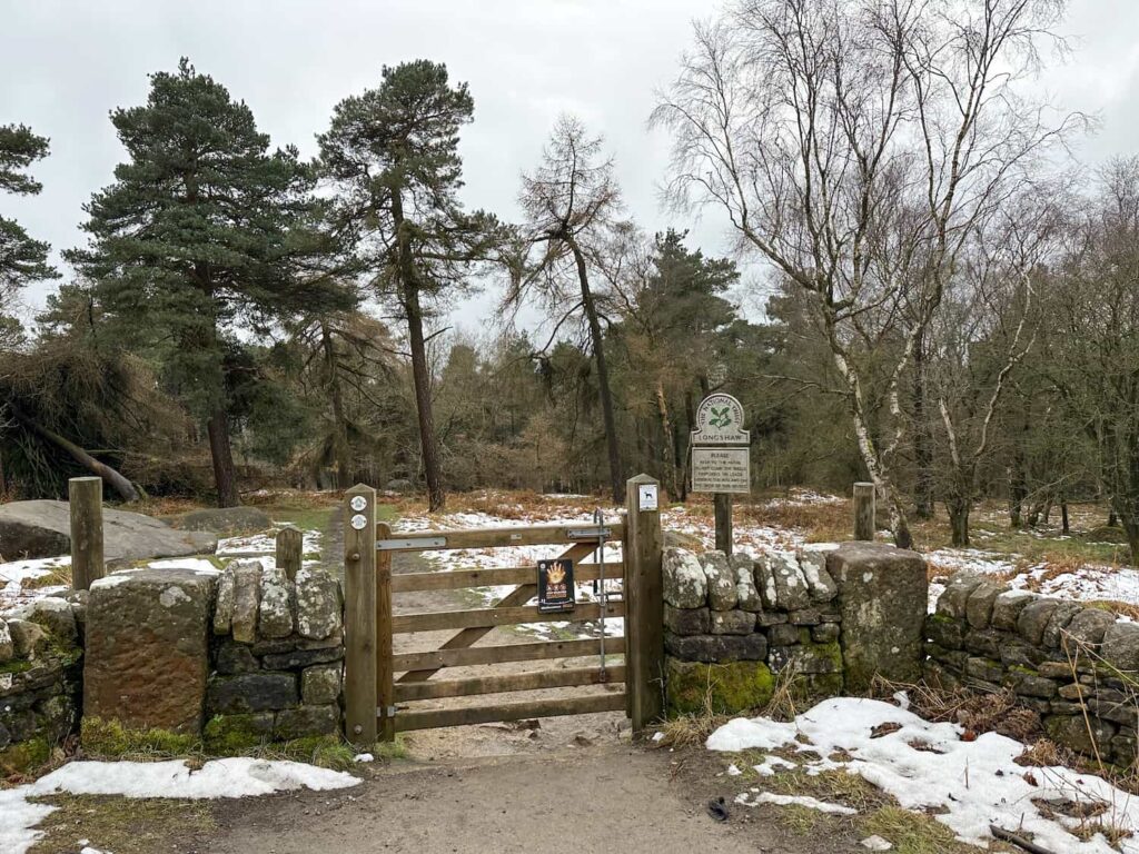 A wooden gate with a National Trust sign to Longshaw Estate