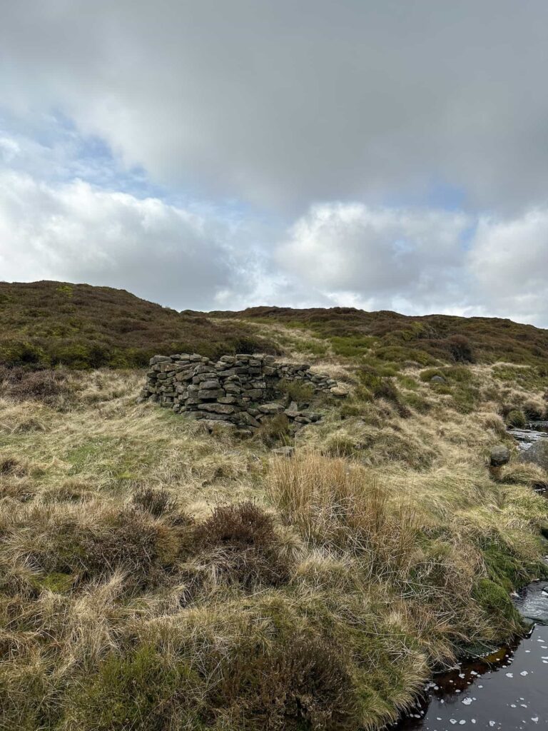 The remains of Four Jacks Cabin, little more than a low stone wall now