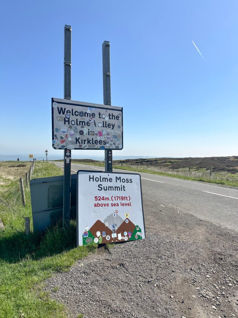 An image of a sign reading "Holme Moss summit"