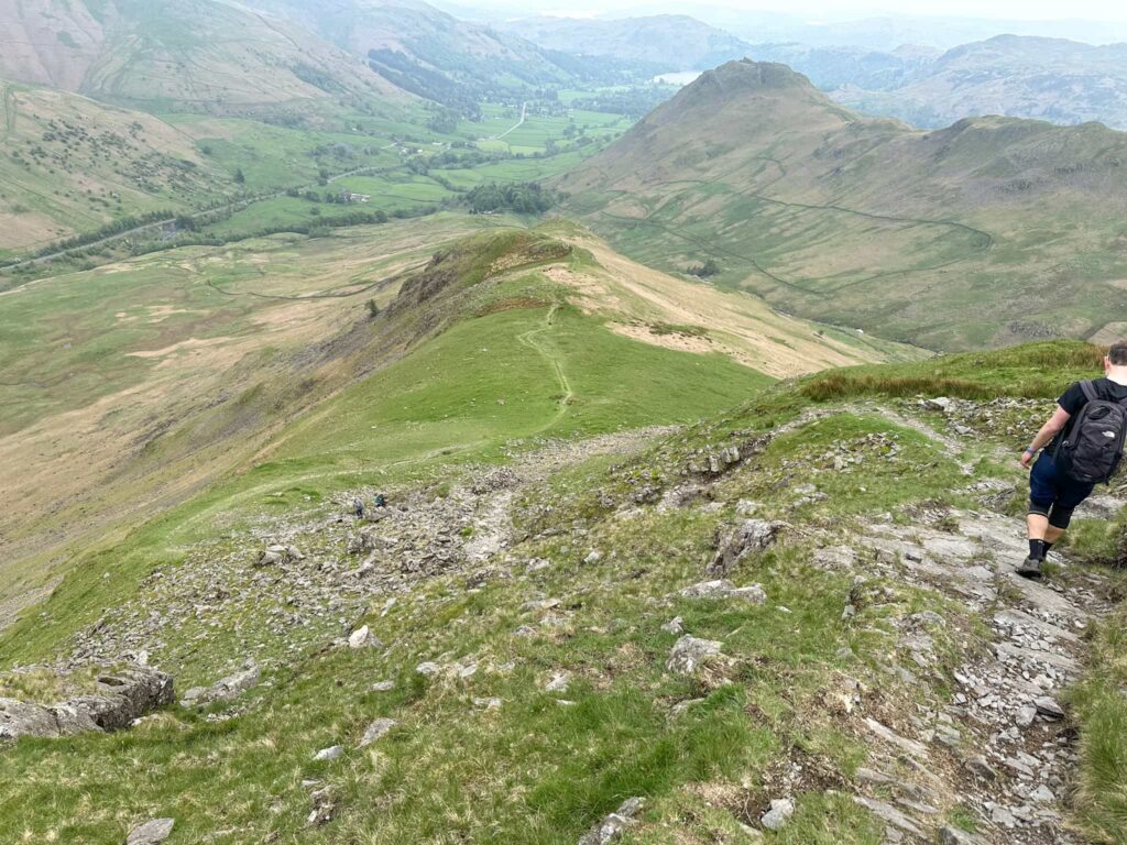 Heading down a rocky path with Helm Crag in the background