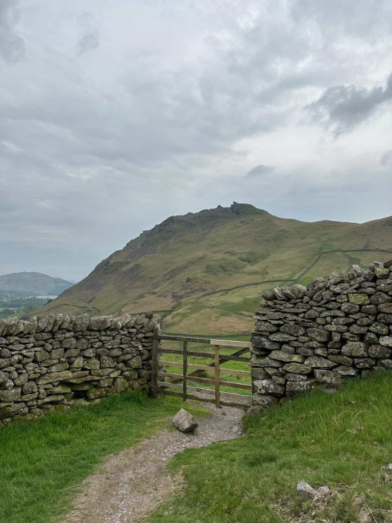 A wooden gate with a view of Helm Crag beyond