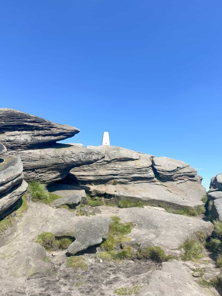 A white trig point on top of some rocks at Back Tor