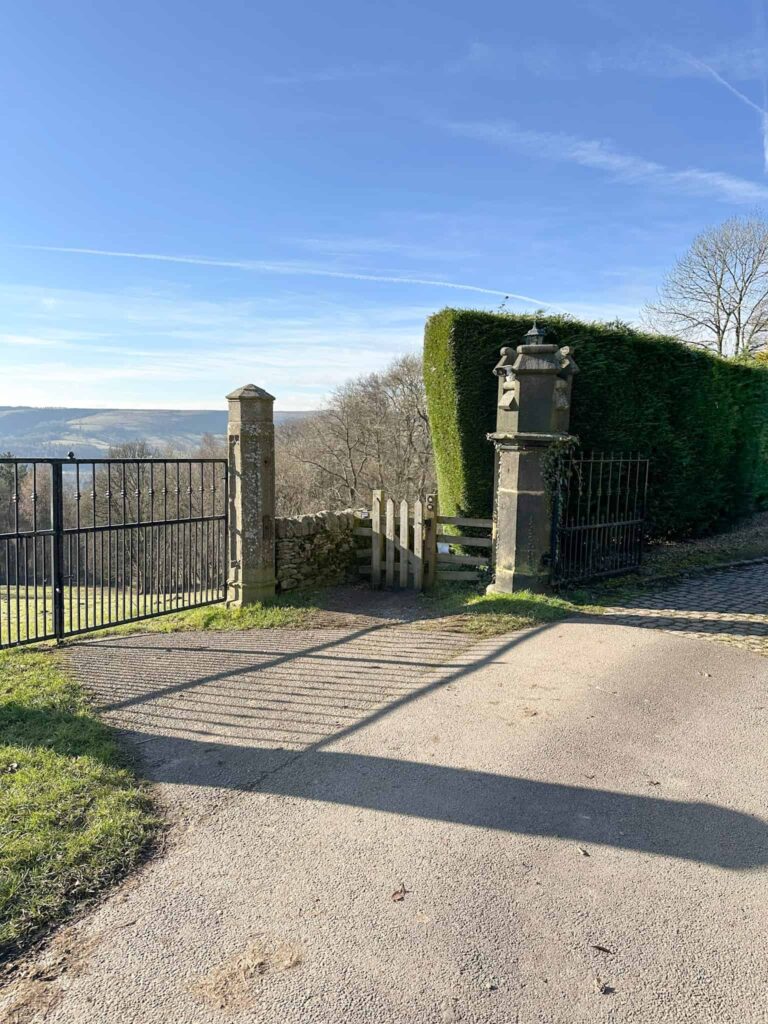 A wooden gate next to a stone gatepost