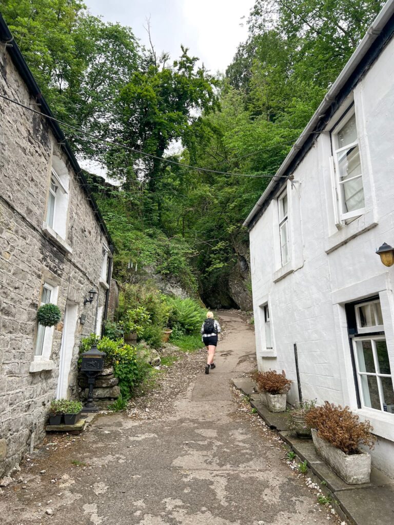 A woman walking between two cottages