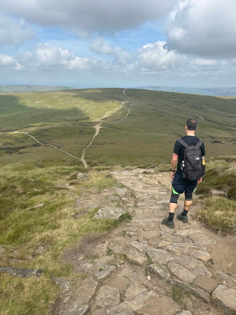 A man looking down at a path coming off Kinder Scout