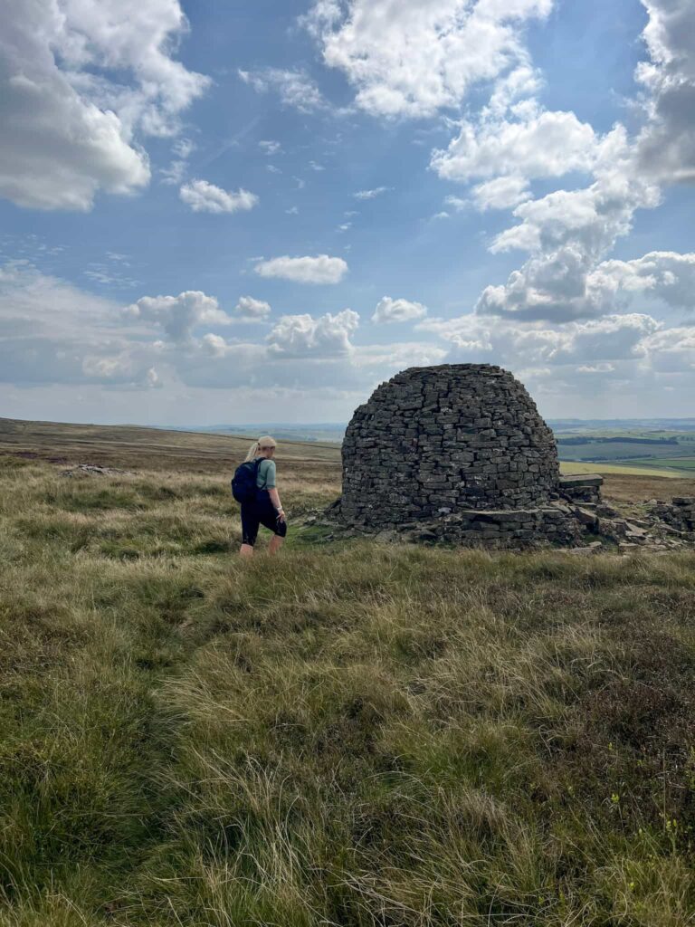 A woman heading to a stone igloo on Brown Knoll