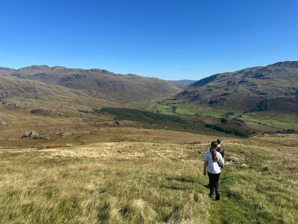 A man and his daughter walking on Harter Fell towards Hard Knott