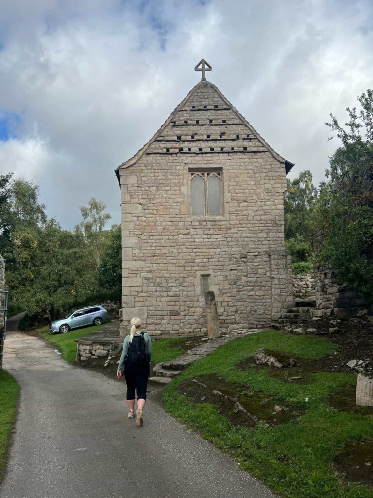 A woman walking next to an old chapel