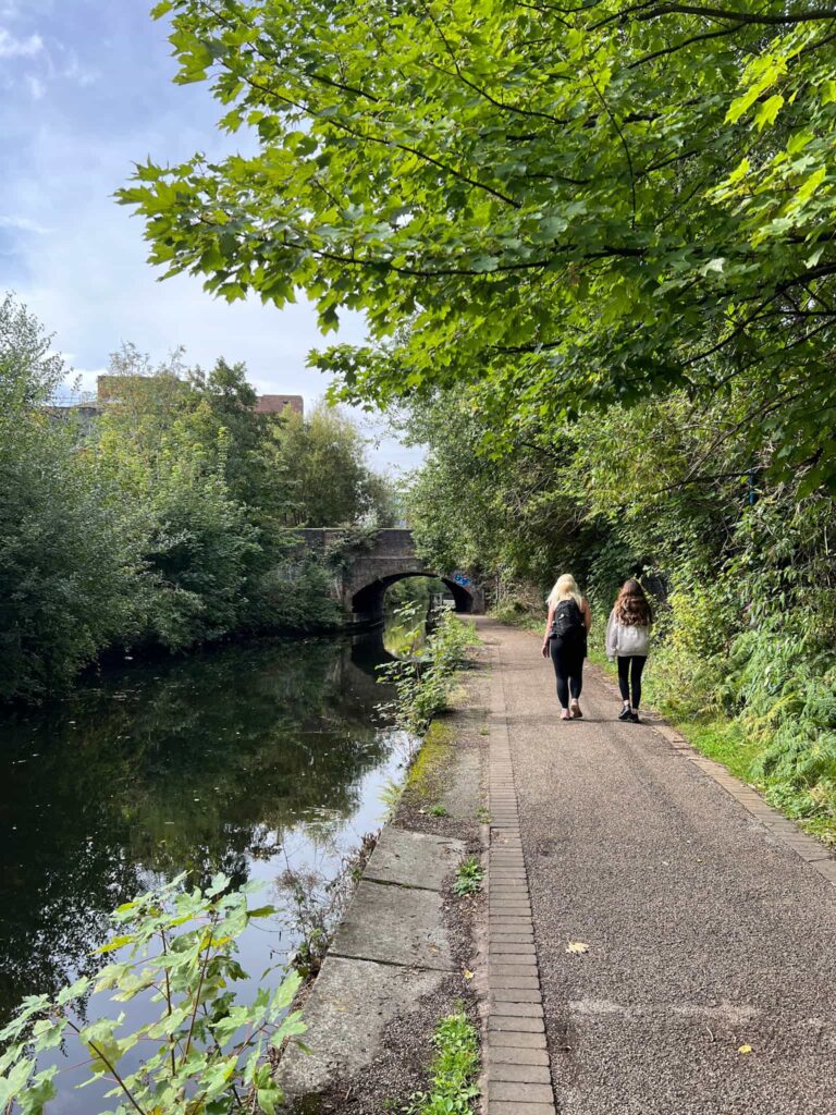 A woman and a girl walking on a canal path