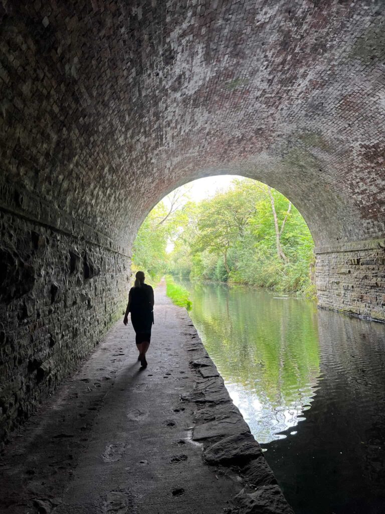 A woman walking through a canal tunnel