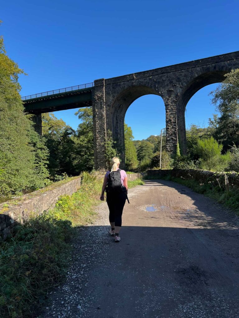 A woman walking near a viaduct