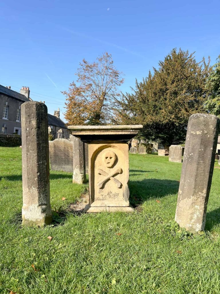 A grave in Eyam with a skull and crossbones motif