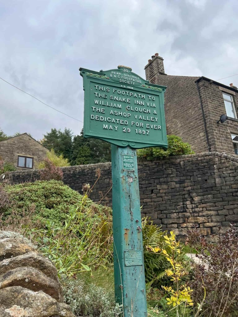 A green sign commemorating Snake Path