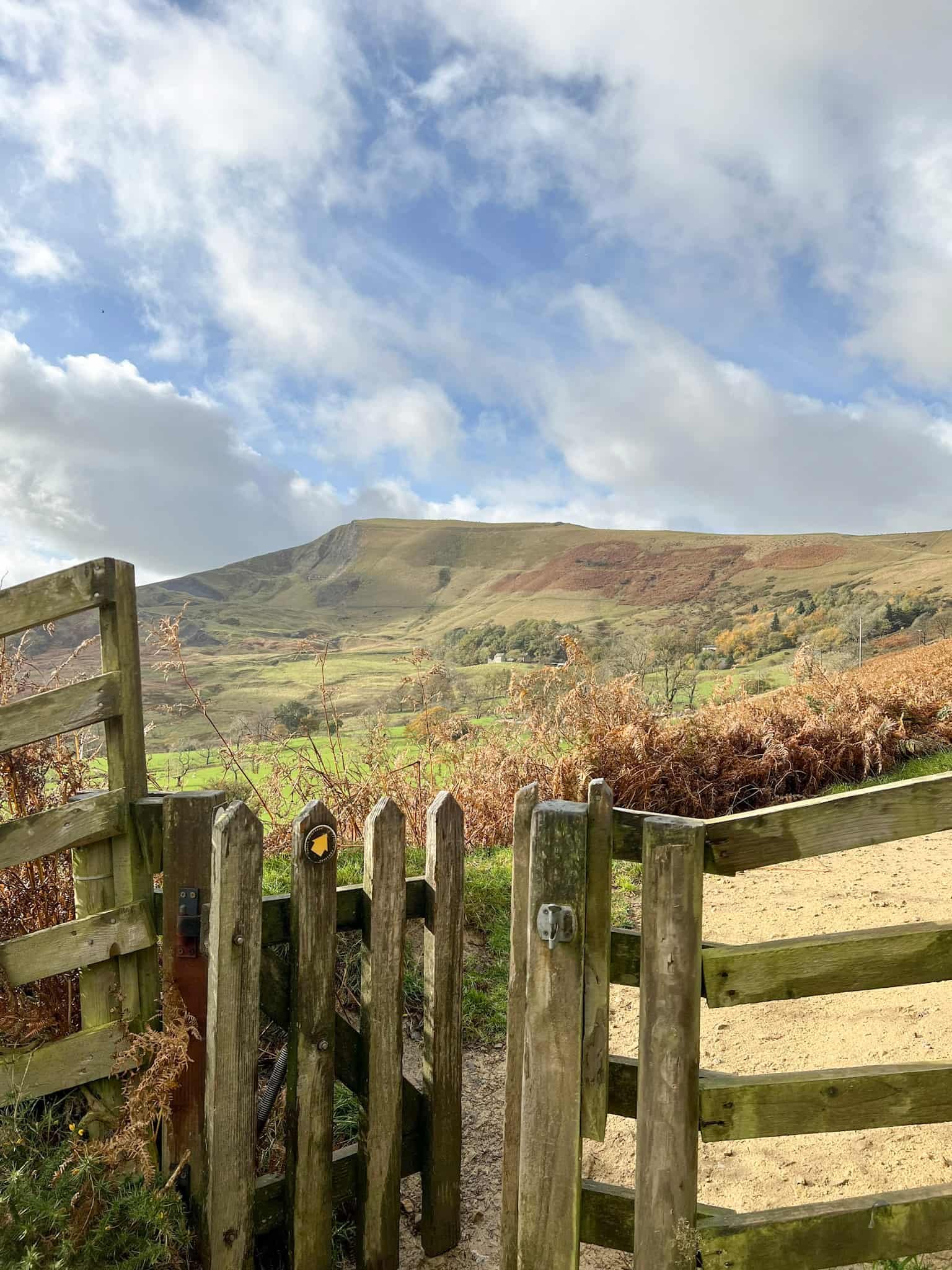 A view of Mam Tor with a small wooden gate in the foreground