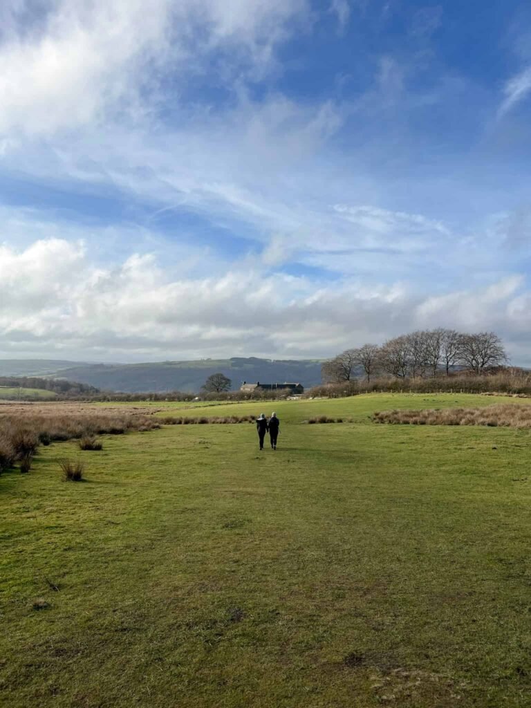 A woman and her daughter walking across a field