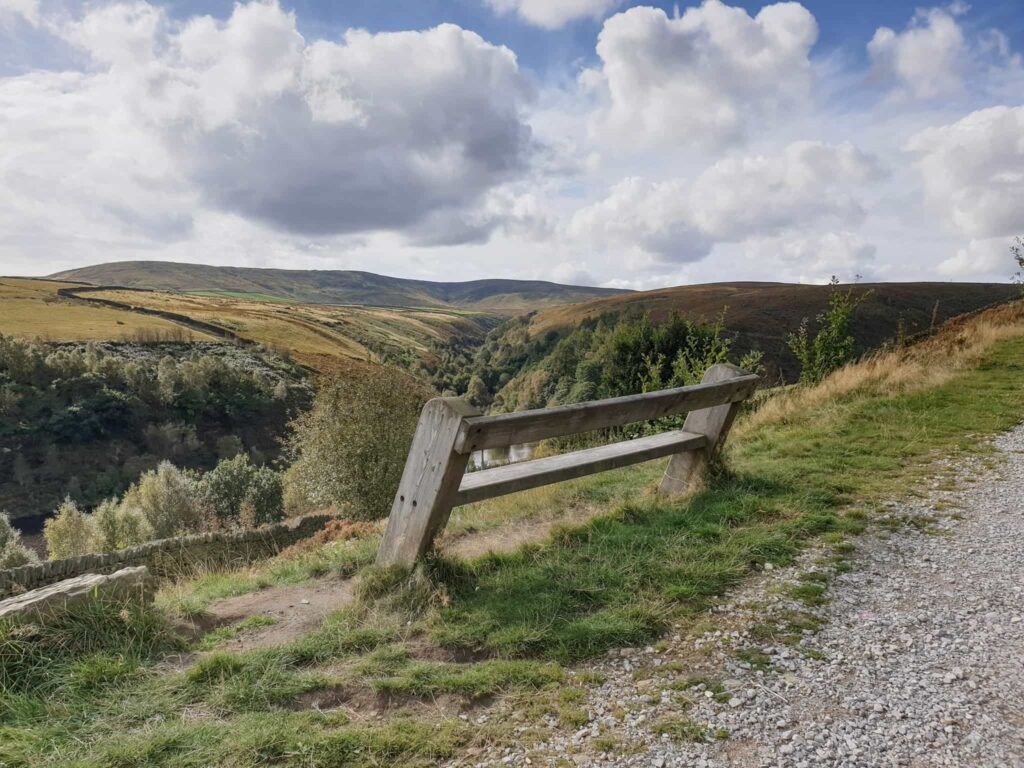 A wooden bench with a moorland view beyond