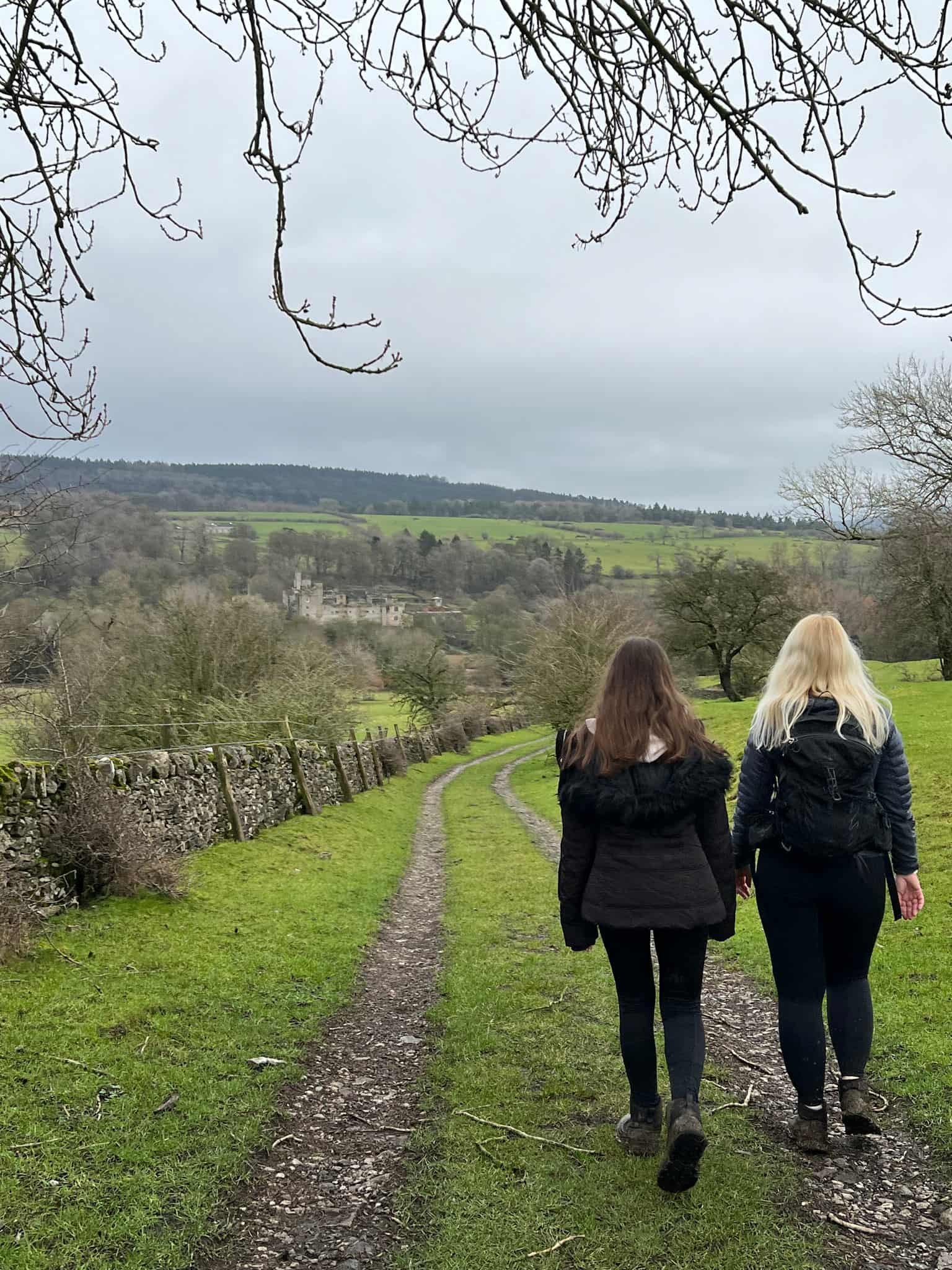 A woman and her daughter walking through a field