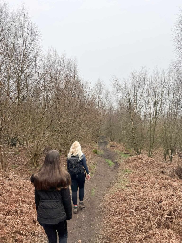 A woman and her daughter walking through woodland