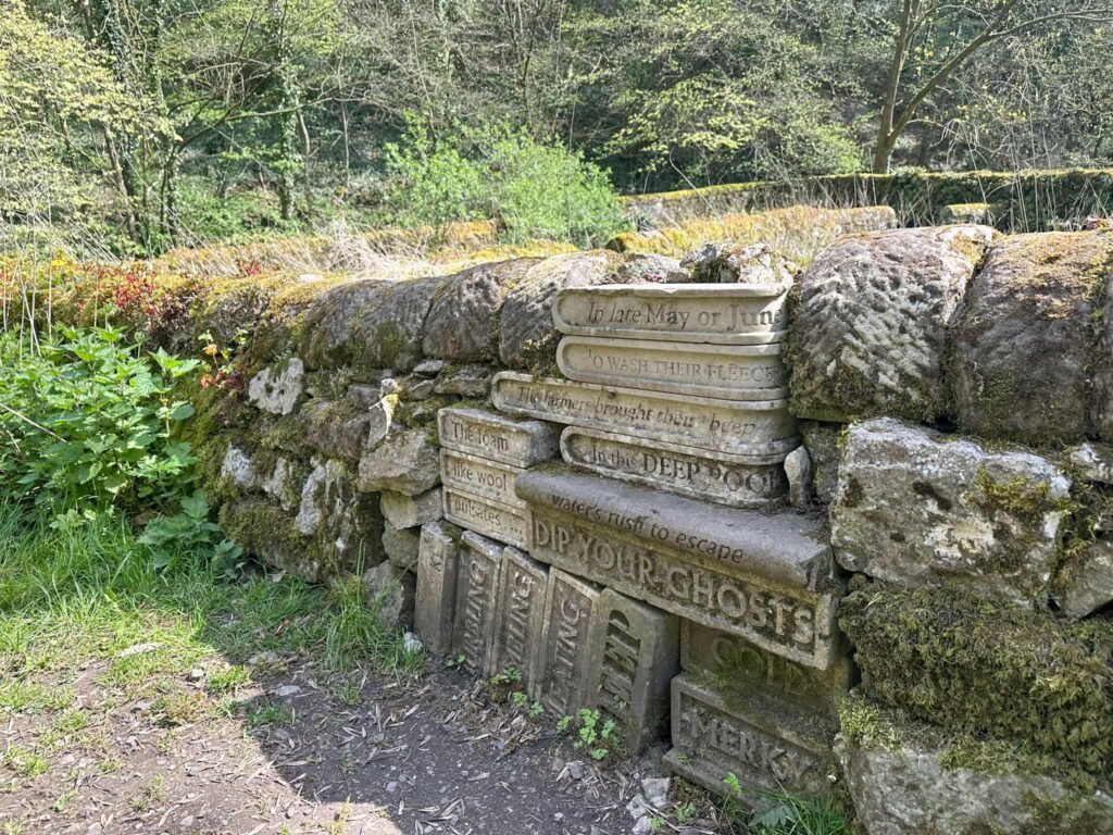 A sculpture of a stack of books carved into the wall near Bradford Dale, Youlgreave,