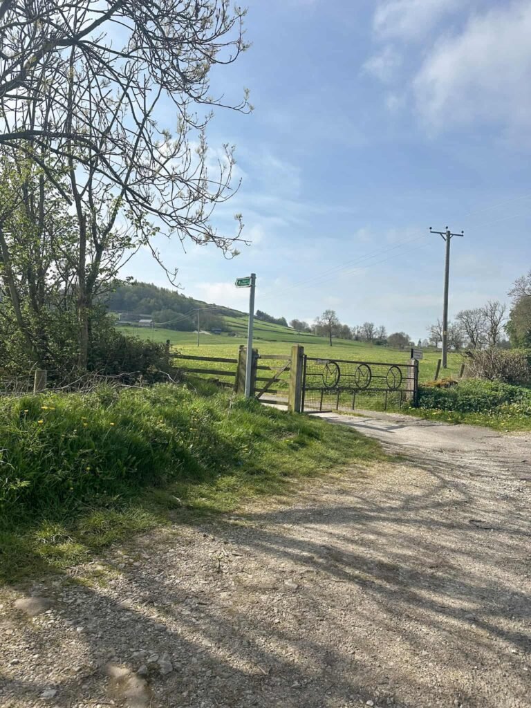 A metal gate and footpath sign