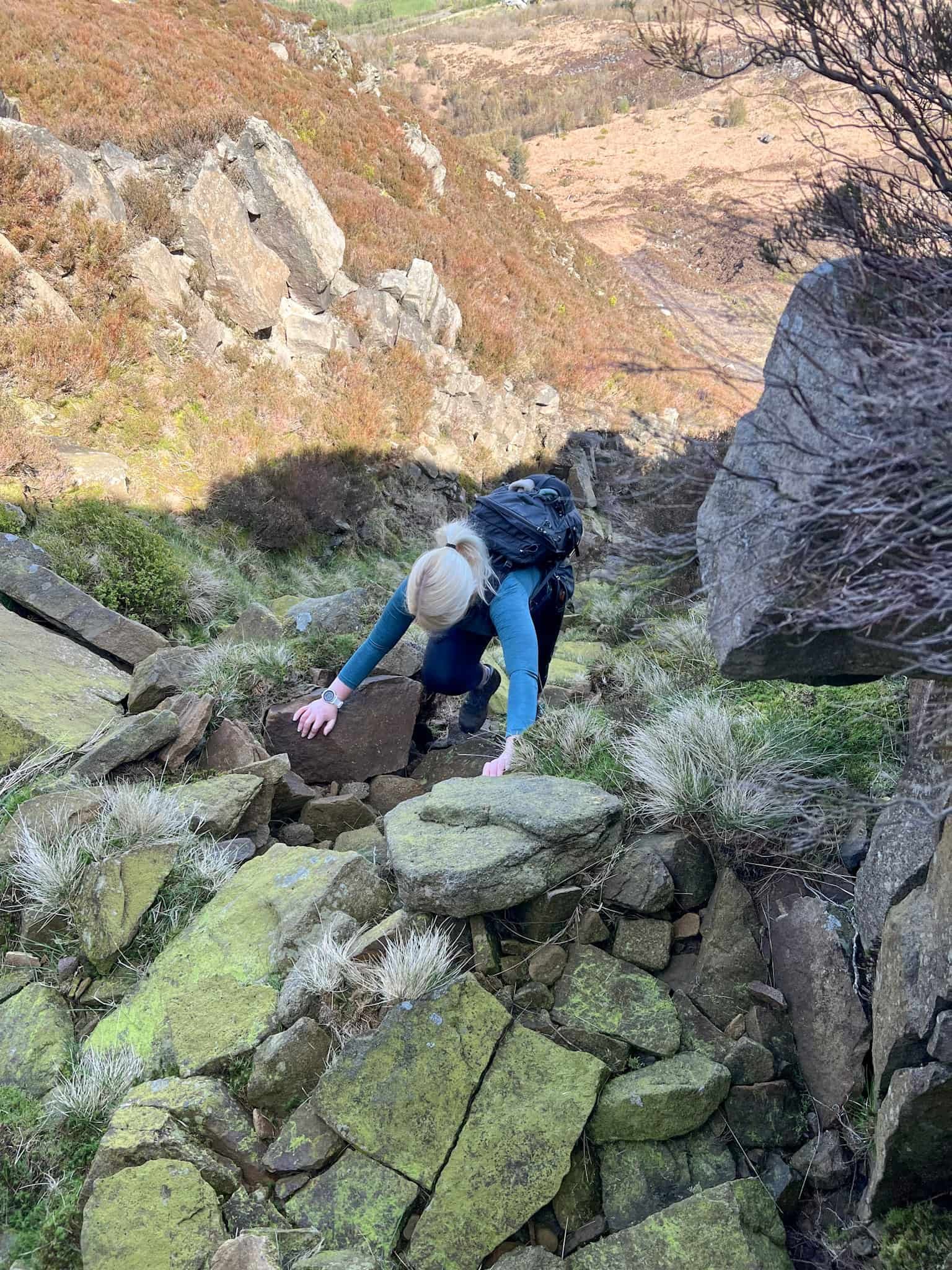A woman climbing up some rock