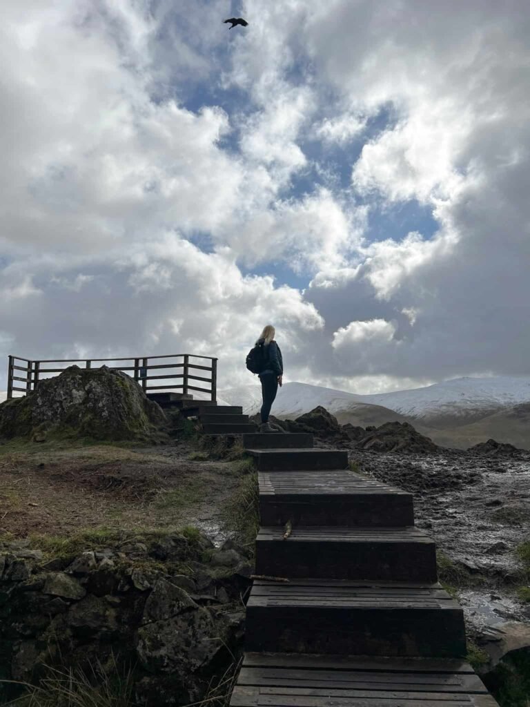 A woman silhouetted at the top of Raven Crag