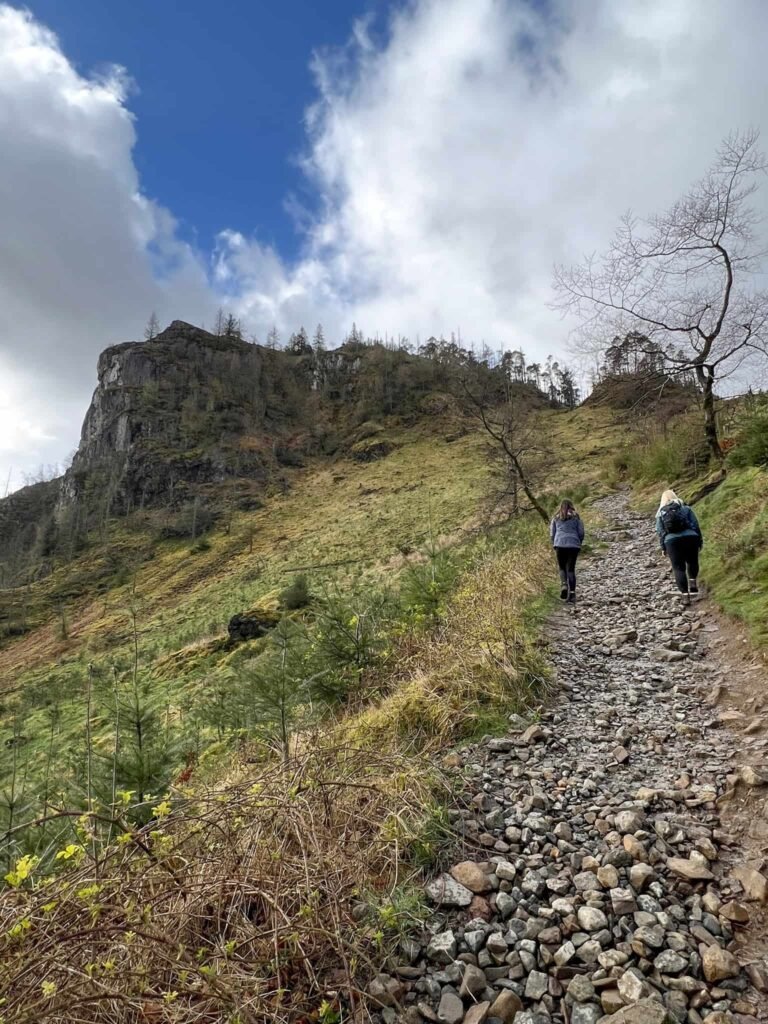 A woman and her daughter climbing the steep path up to Raven Crag