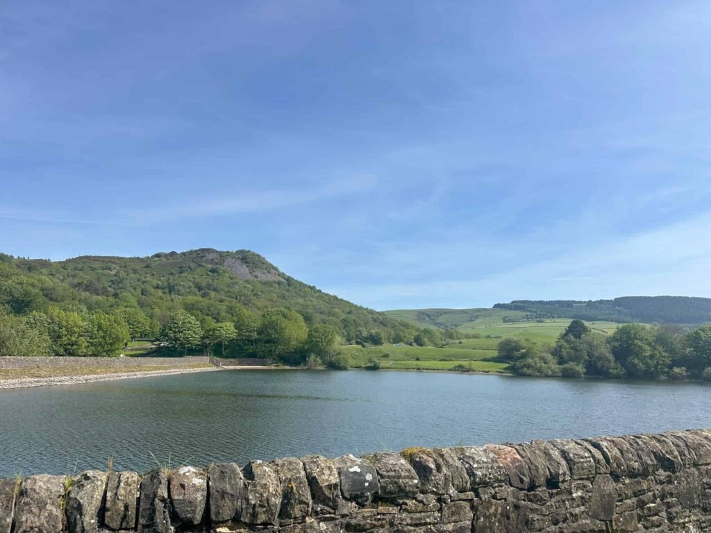 A view across a reservoir to Teggs Nose, a hill in Cheshire