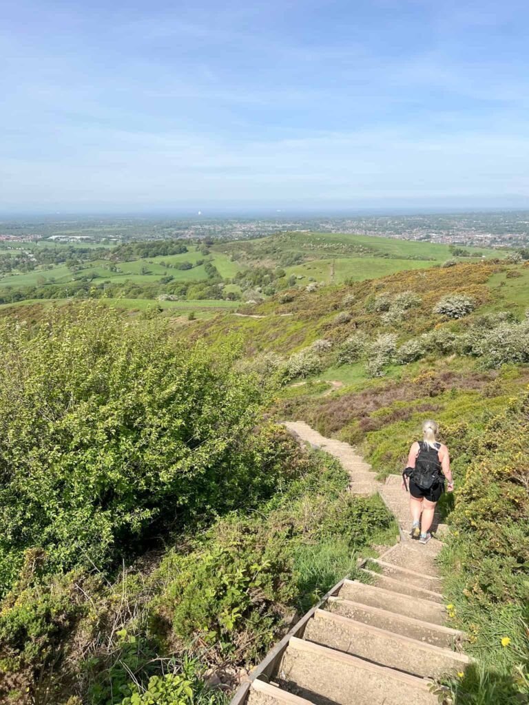 A woman walking down a steep stepped hillside