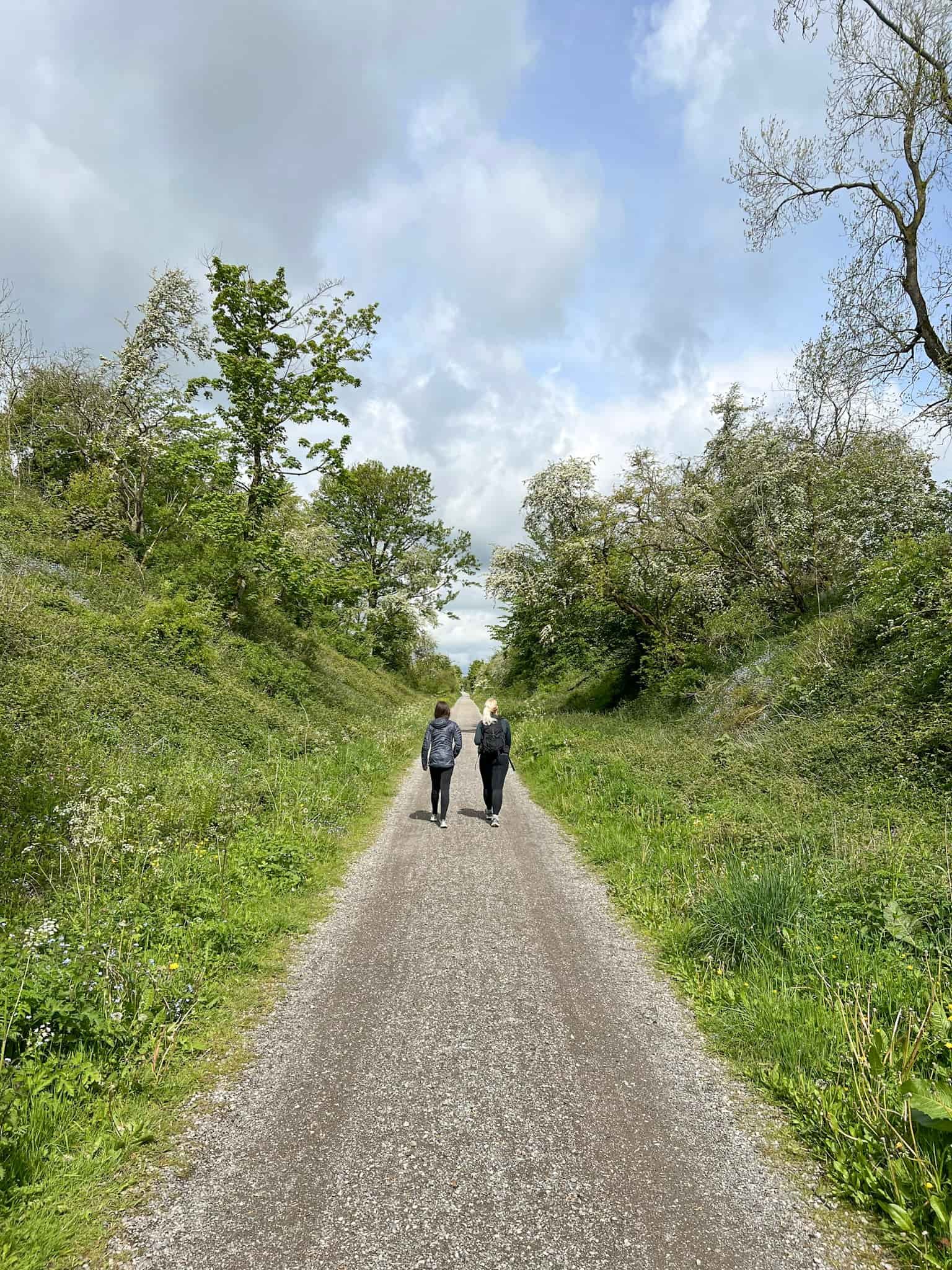 A woman and her daughter walking on a trail