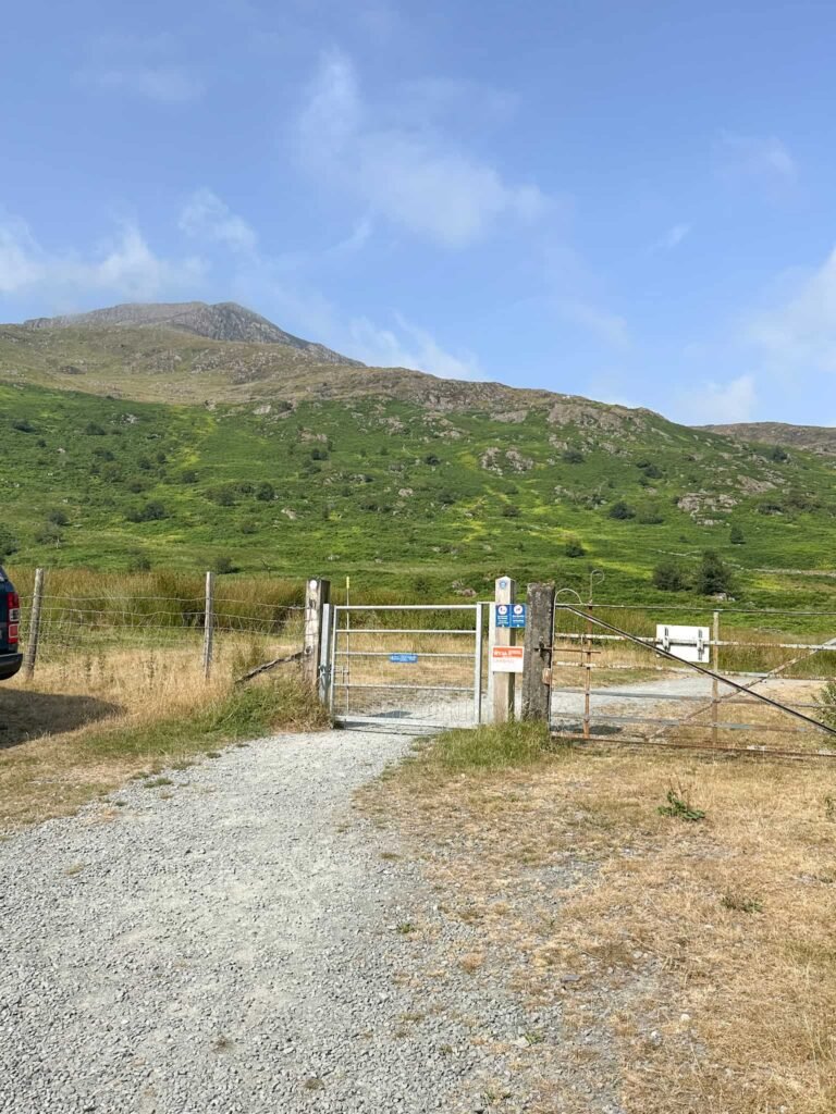 A metal gate with Moel Hebog in the background