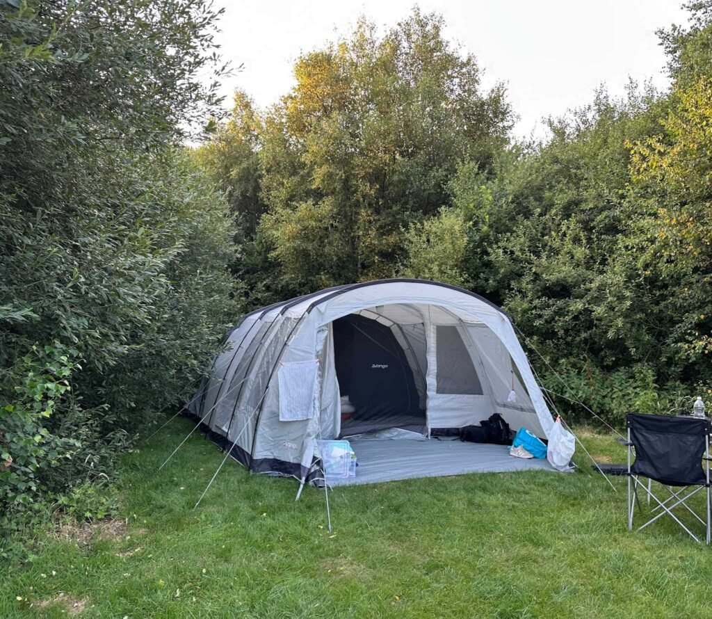 A light grey tent in some woods
