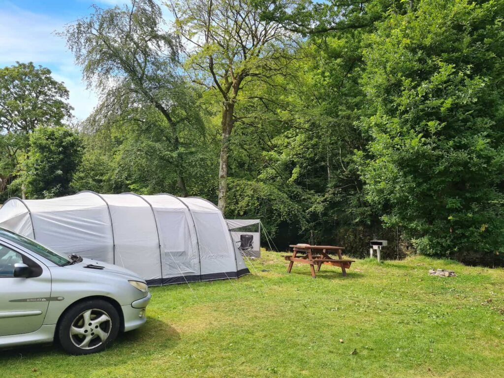 A grey tent and silver car