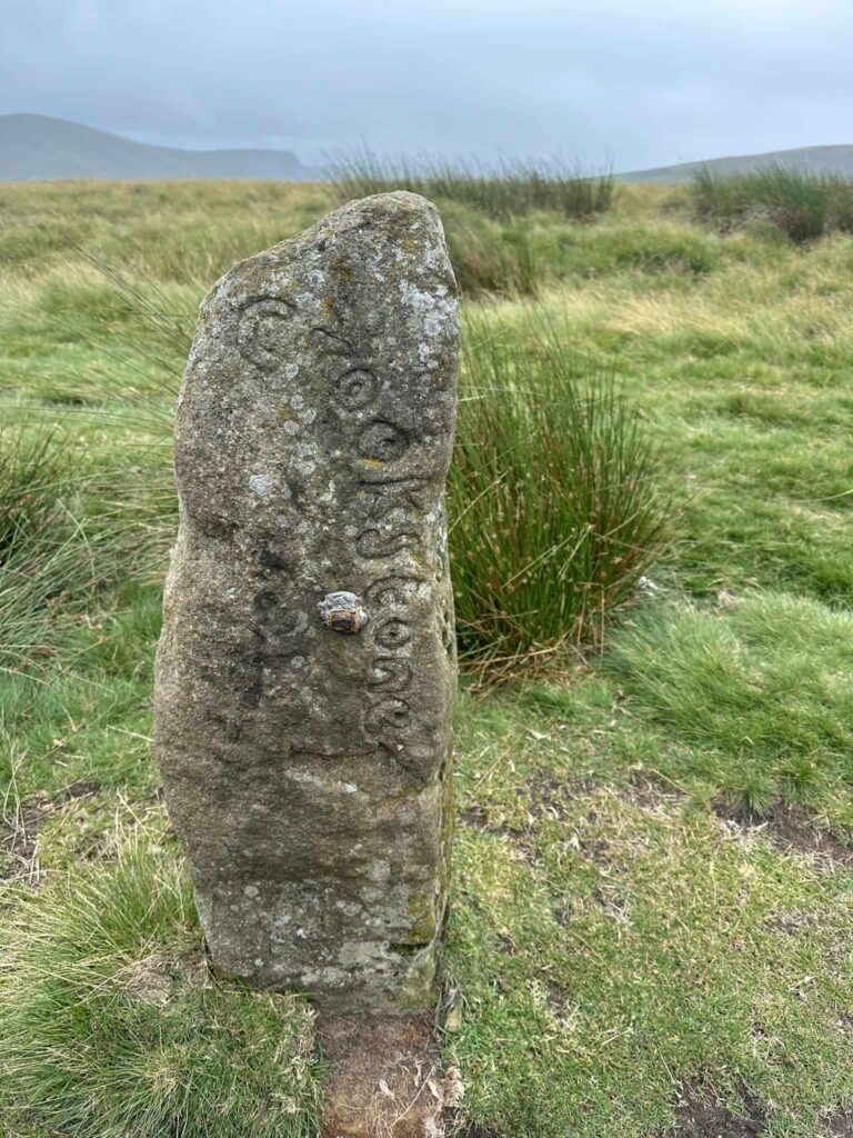 An old stone gatepost with the word Crookstone carved onto it, on Crookstone Hill