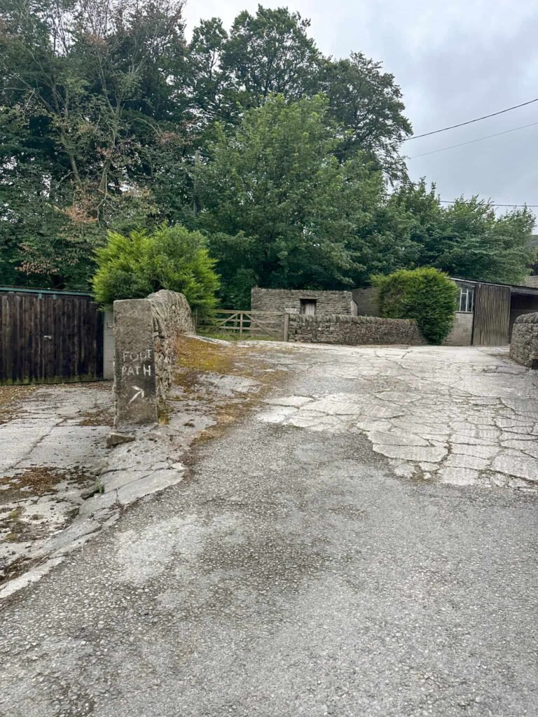 A footpath running through some farmyard buildings