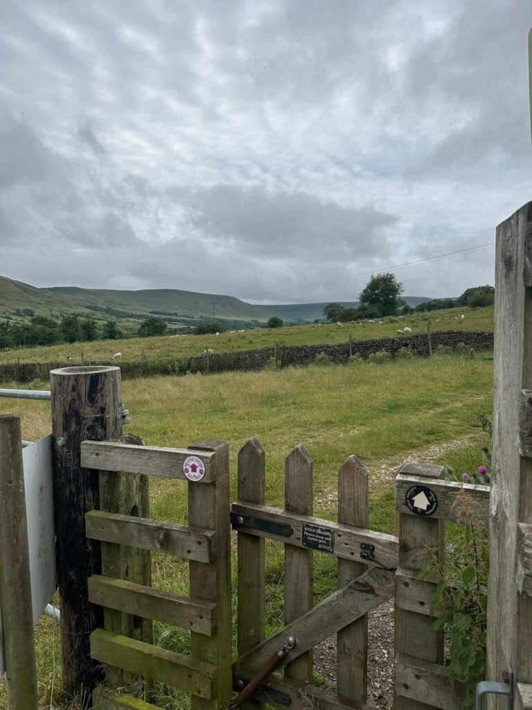 A wooden gate with a field view beyond