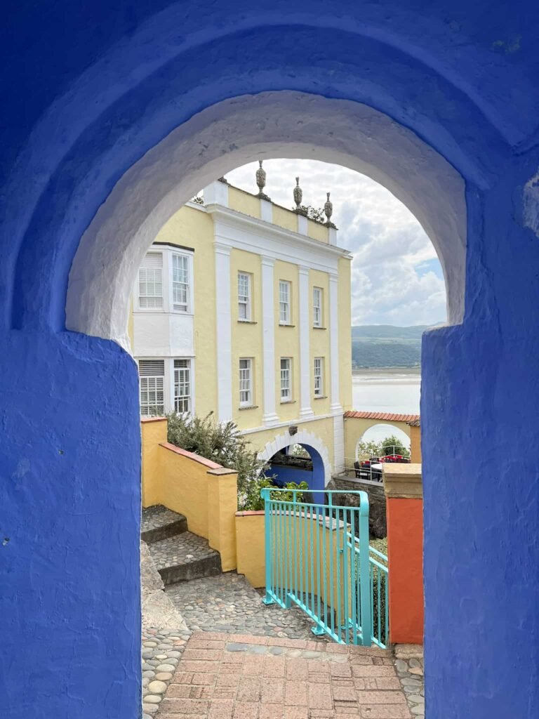 Colourful buildings in Portmeirion as seen through a blue archway