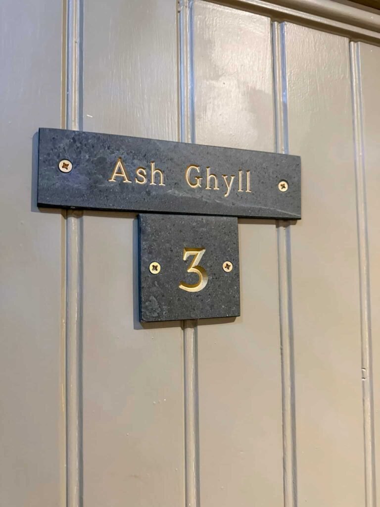 Sign for Ash Ghyll on a wooden door