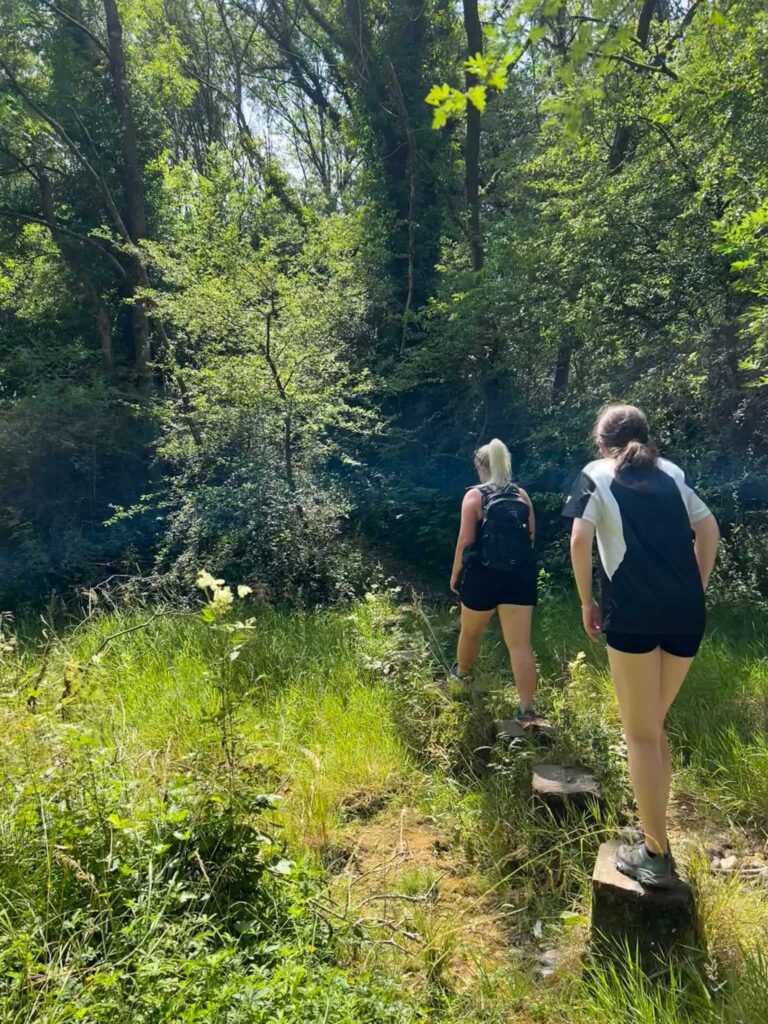 A woman and a girl crossing a dried up river bed on stepping stones