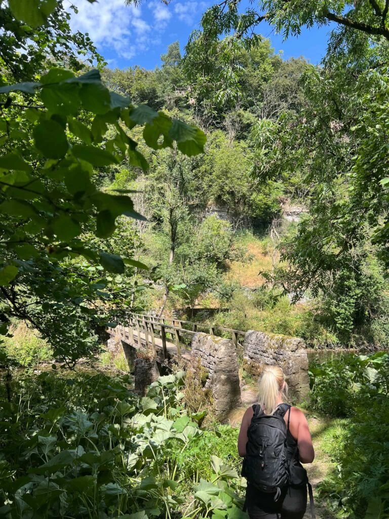 A woman walking over a footbridge across the River Wye