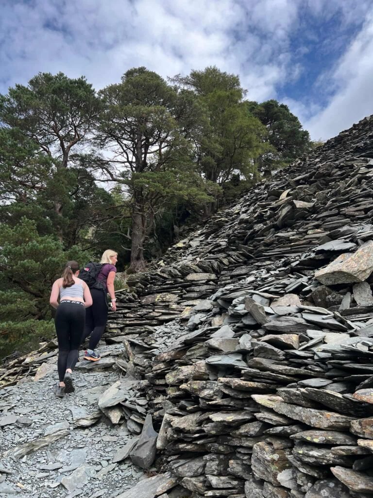 A woman and her daughter walking up a steep slate path