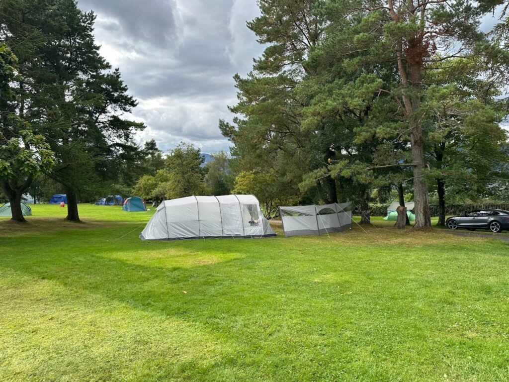 A large grey tunnel tent with a grey windbreak