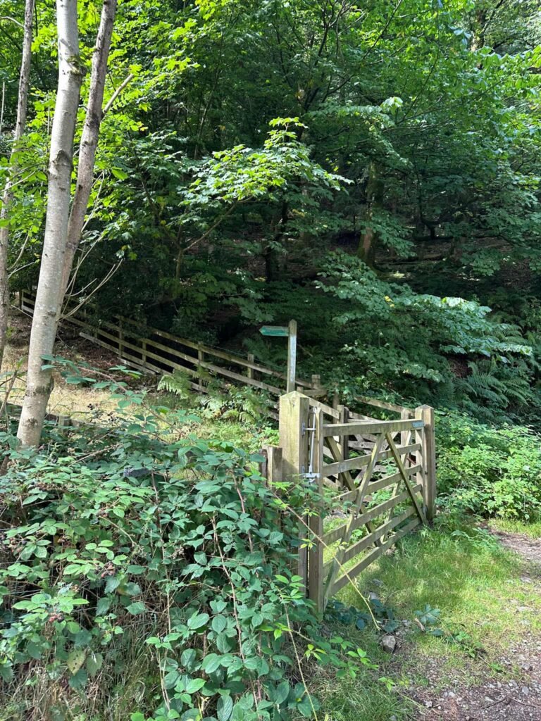 A footpath sign next to a wooden gate near Armboth car park