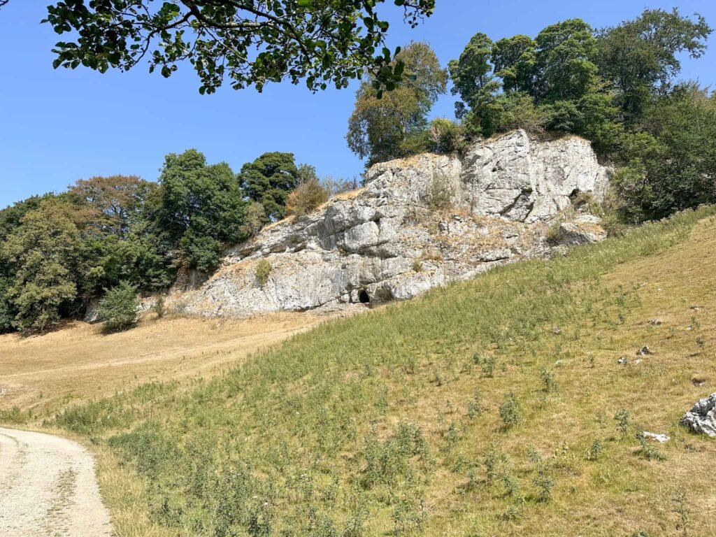 A far distance shot of a cave in Wolfscote Dale
