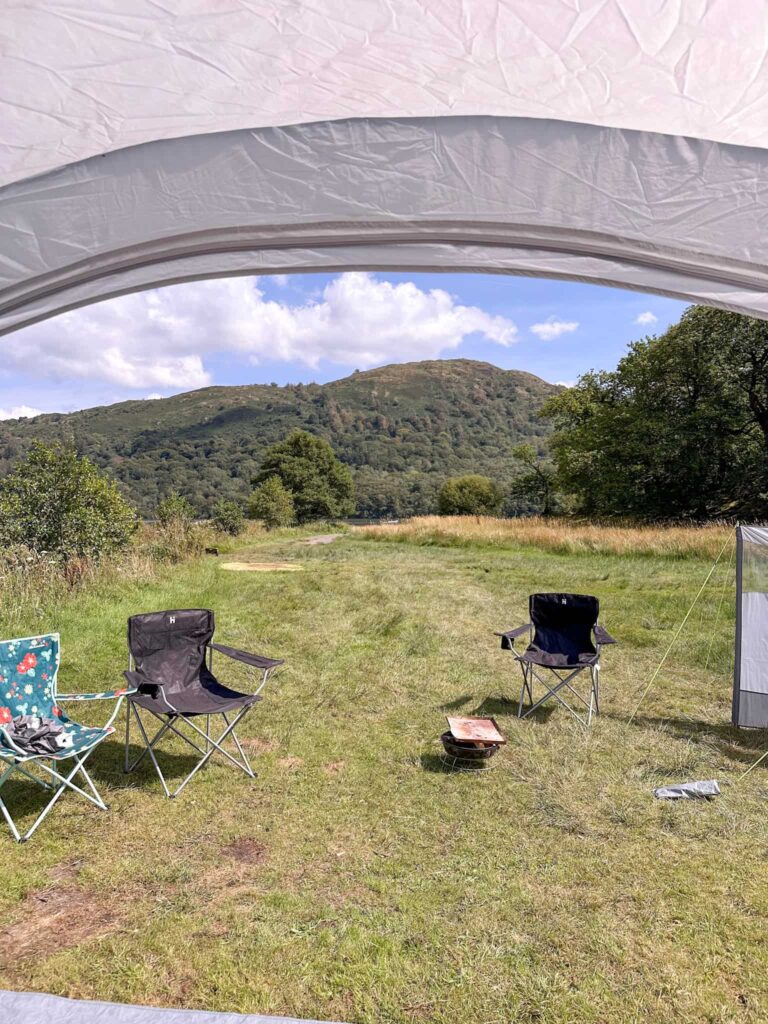 View from a tent, with some camping chairs in the foreground and mountains beyond